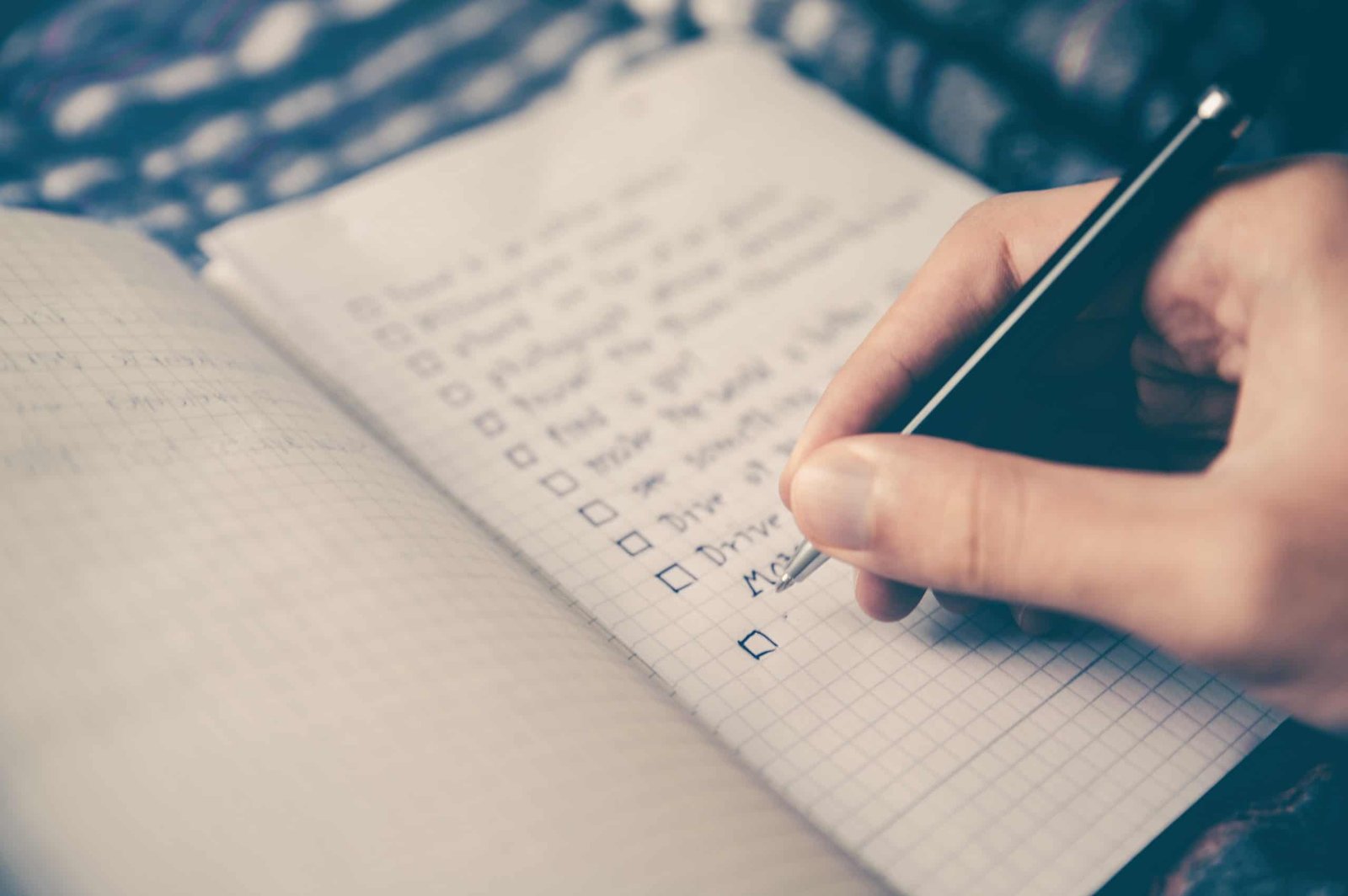 Hand writing a list with a pen on white lined paper