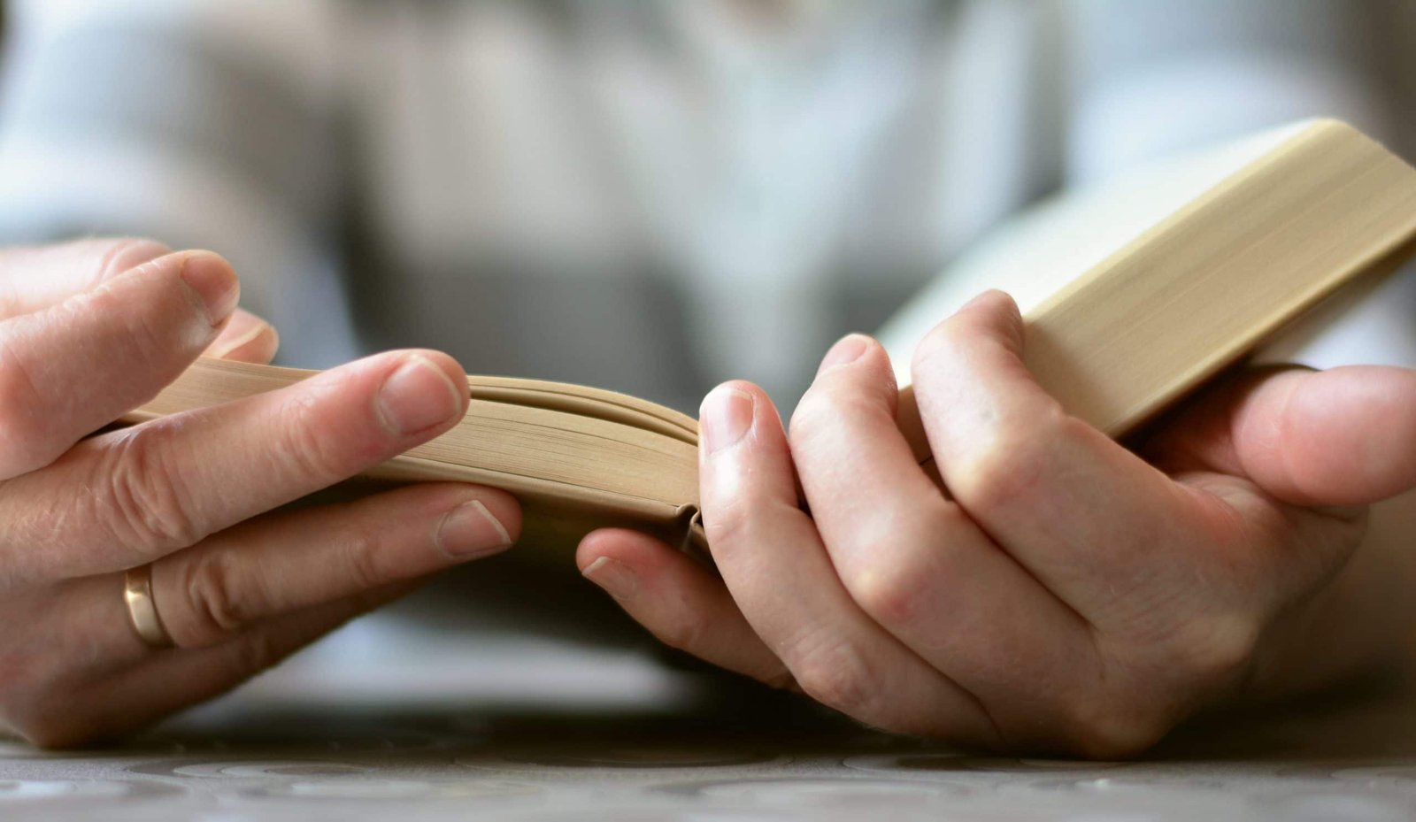 Hands holding a book open