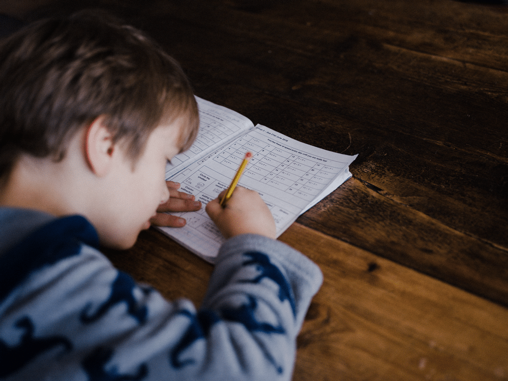 male student writing in workbook