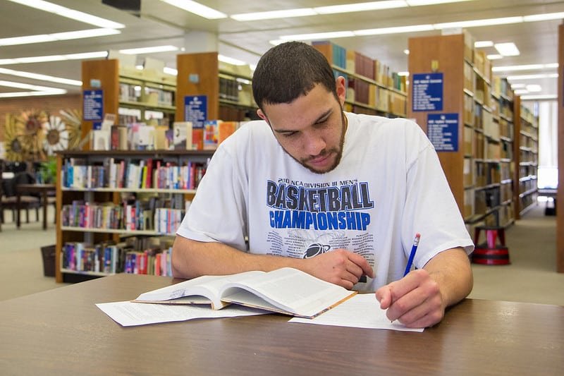 high school male student studies in the library