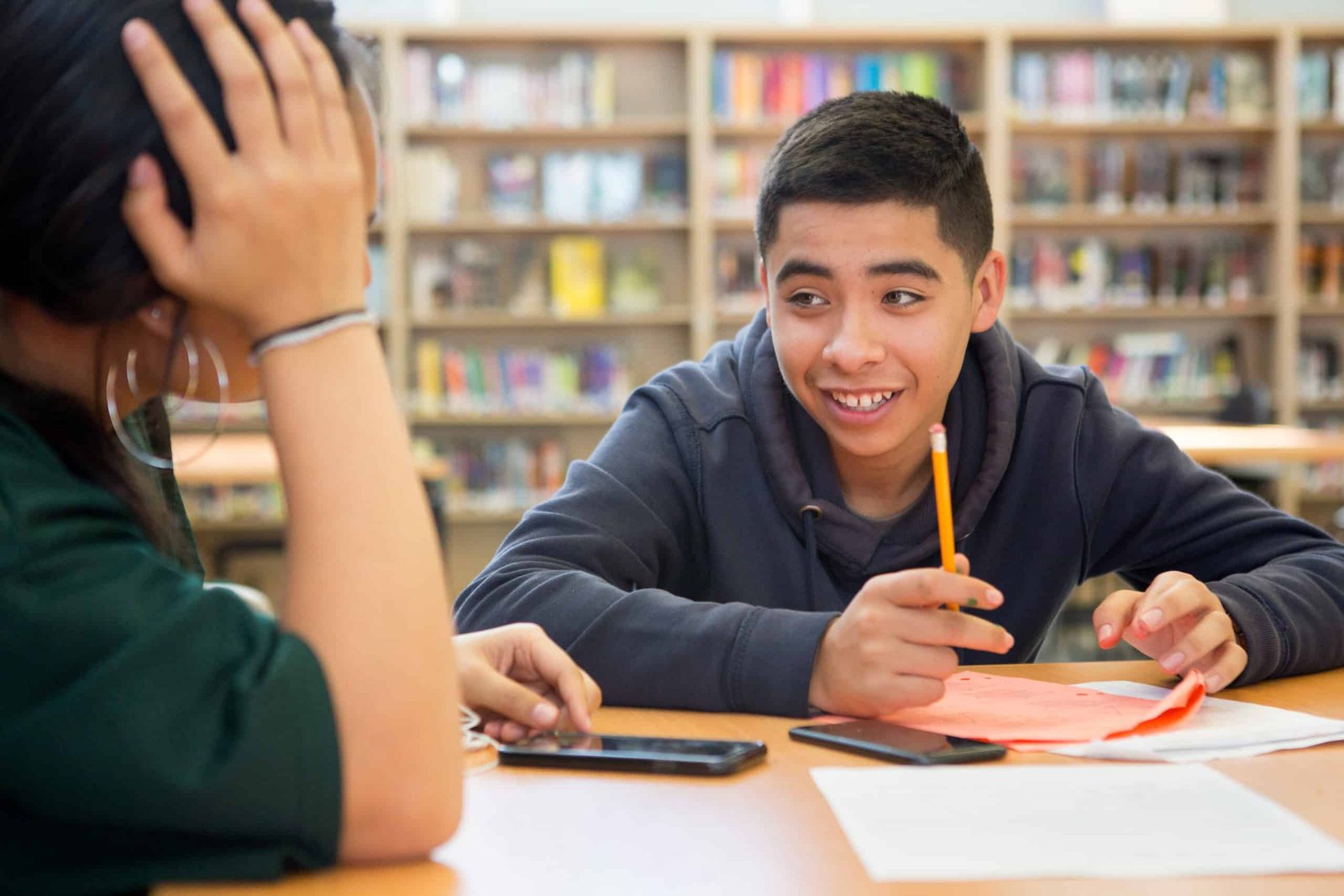 High school boy writing in library