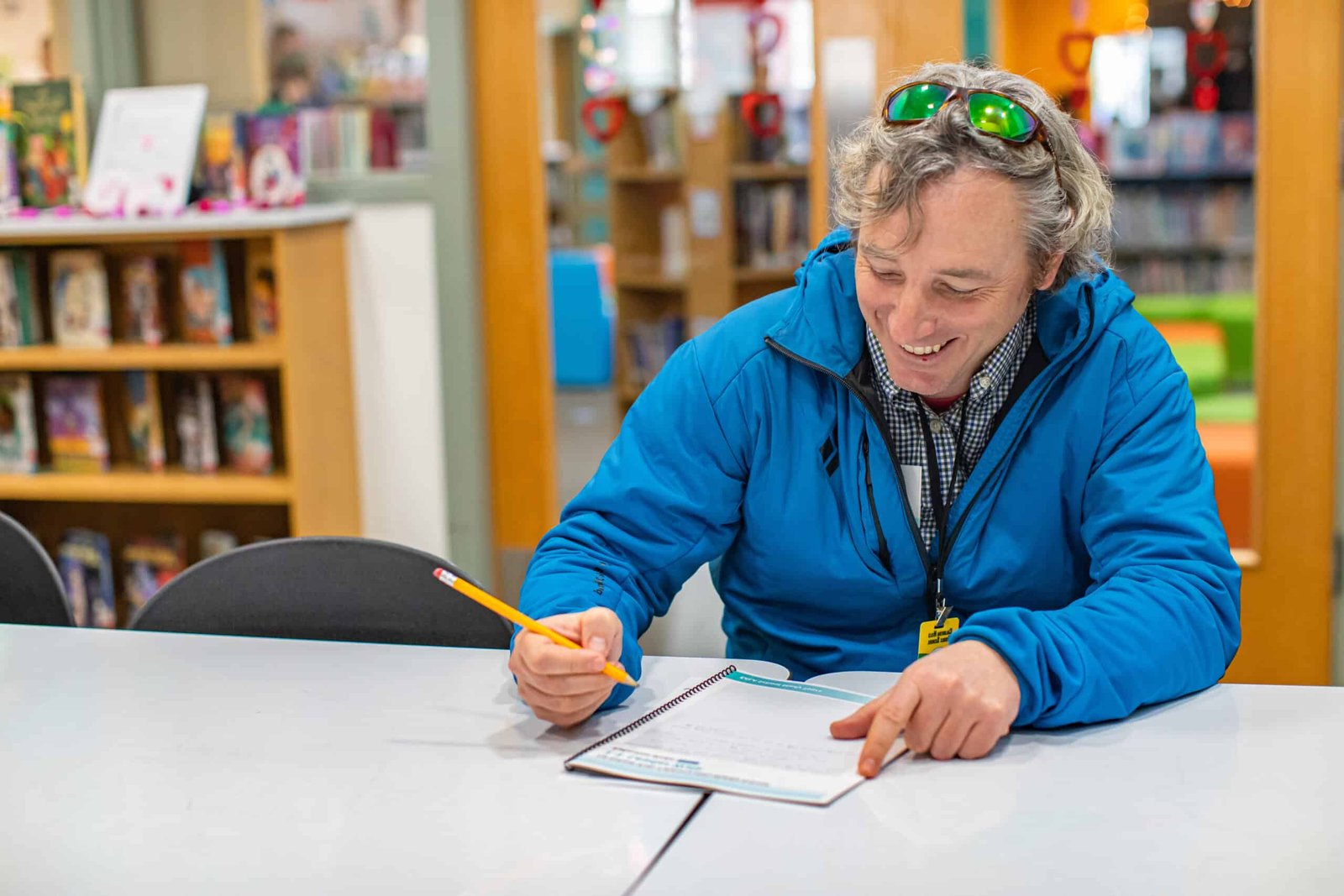 Man in a blue jacket writing
