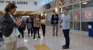 A group of adults being led on a high school tour.