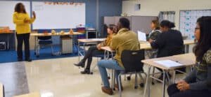 Classroom teacher in the front of a classroom talking to adults