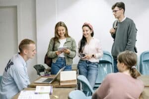 Five adults standing around a table chatting.
