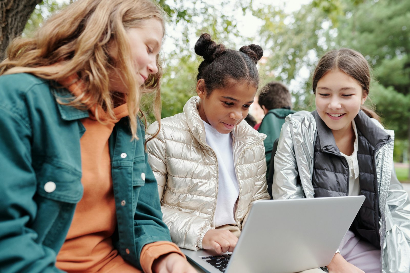 Three students sitting around one laptop